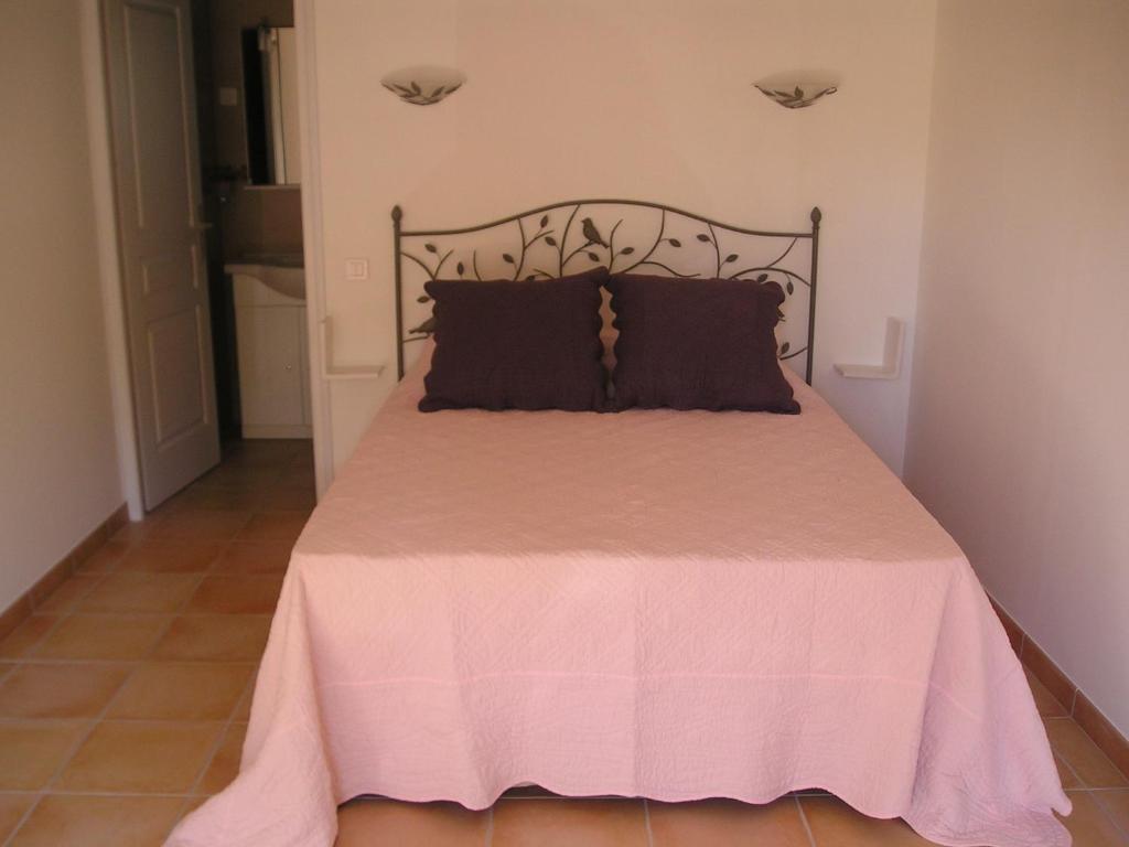 博尼法乔E Stelle di A Bella Vista的一间卧室配有一张粉红色的床和黑色床头板
