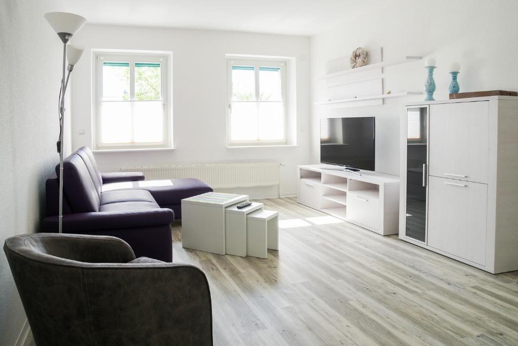 格赖夫斯瓦尔德Apartmenthaus Eldena的白色的客厅配有沙发和椅子