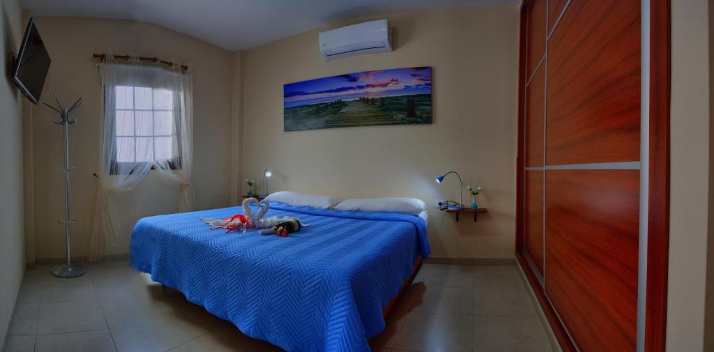 格拉纳迪利亚德亚沃纳Casa Yoel的一间卧室配有蓝色的床和玩具