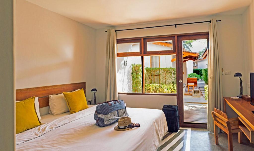 湄南海滩Escape Beach Resort - SHA Extra Plus Certified的一间卧室配有一张床、一张书桌和一个窗户。