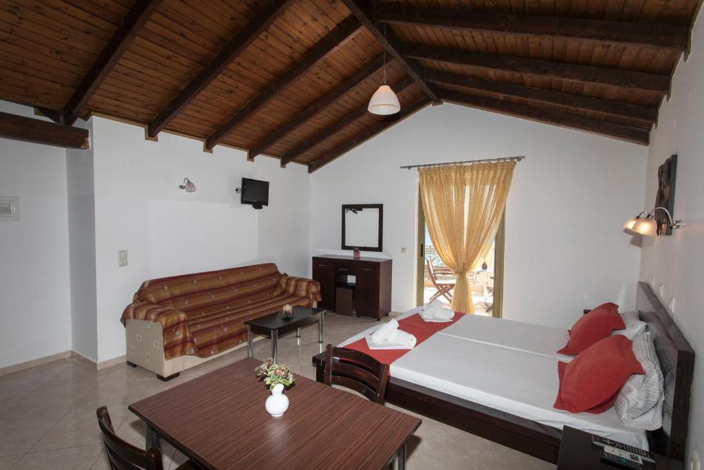 帕拉利亚维拉乔Siarbas Hotel的一间卧室配有一张床、一张桌子和一张沙发