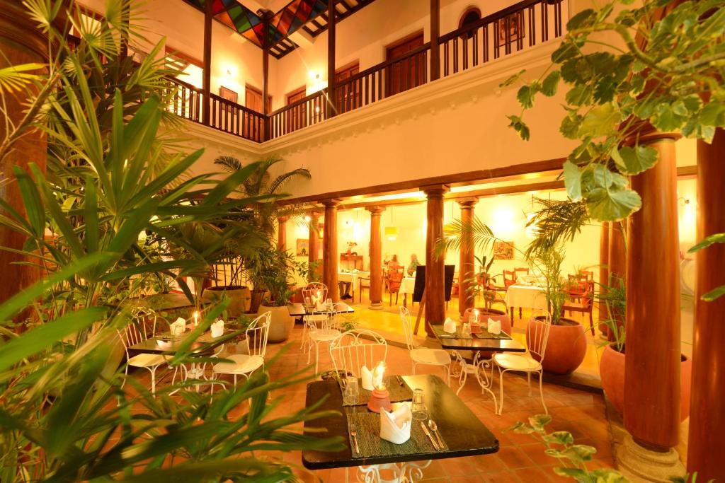 蓬蒂切里Maison Perumal Pondicherry - CGH Earth的大型大堂设有桌椅和植物