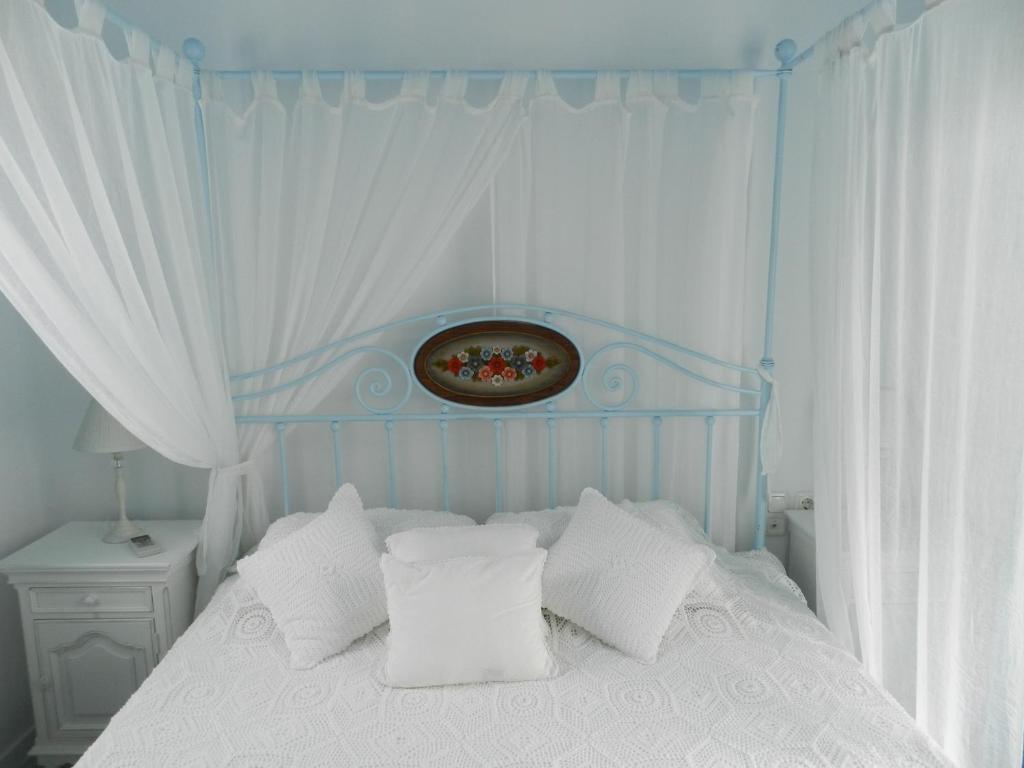 VívlosBelogna Ikons的卧室配有白色的床铺和白色的枕头