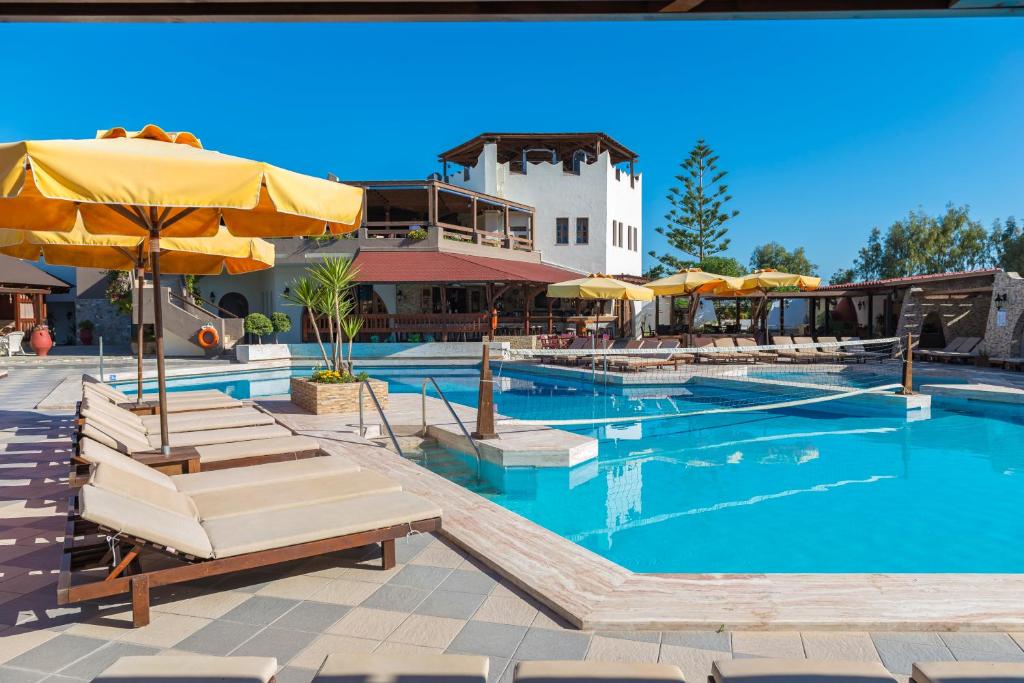 科斯镇盖亚花园酒店的一个带椅子和遮阳伞的大型游泳池