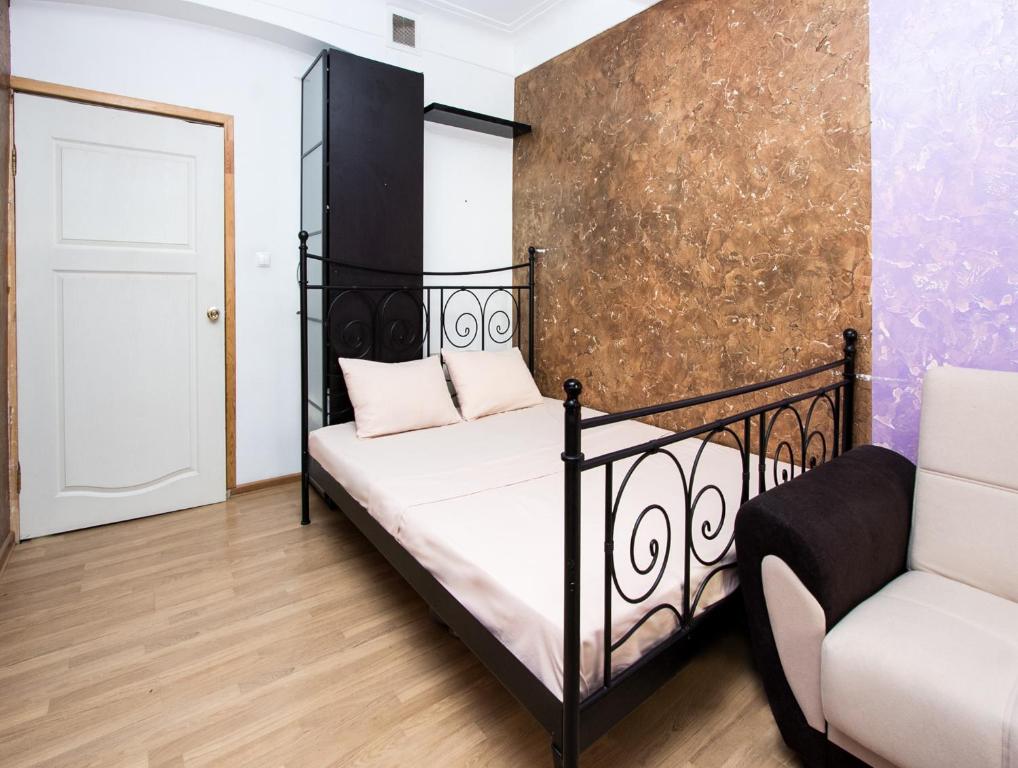 莫斯科克勒穆里奥斯卡亚公寓式酒店的一间卧室配有一张黑色的床和一把椅子