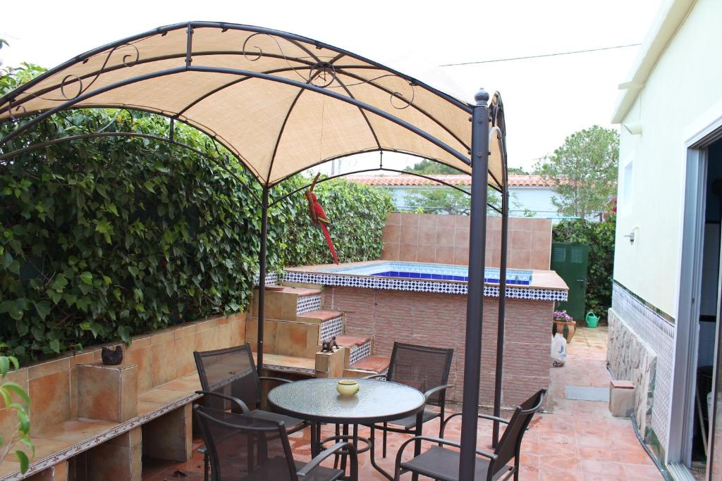 埃尔韦尔赫尔Casa La Madriguera的露台配有桌椅和遮阳伞