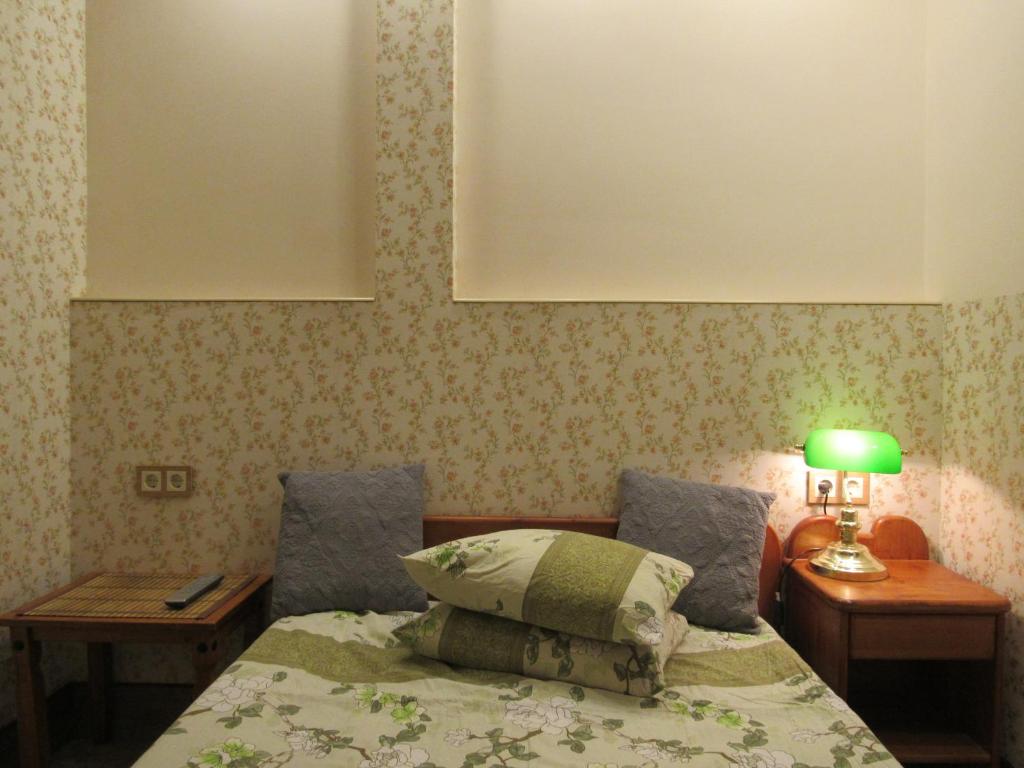 里加AntiK Apart Hotel的一间卧室配有一张带绿灯的床和两张桌子