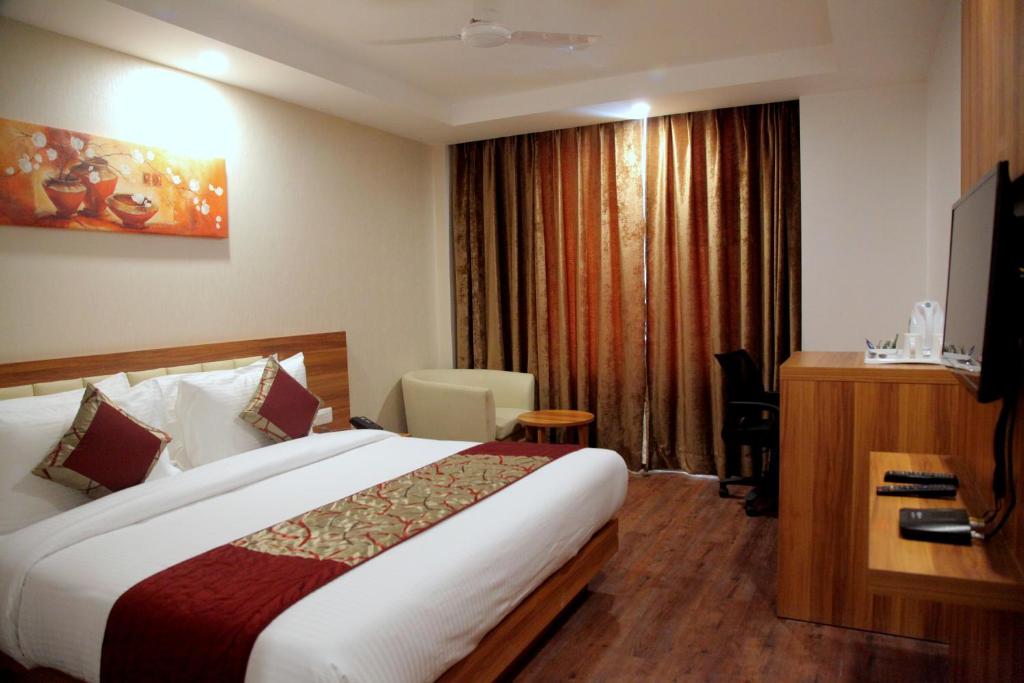 贾姆穆Le Roi Jammu - Near Jammu Railway Station的配有一张床和一张书桌的酒店客房