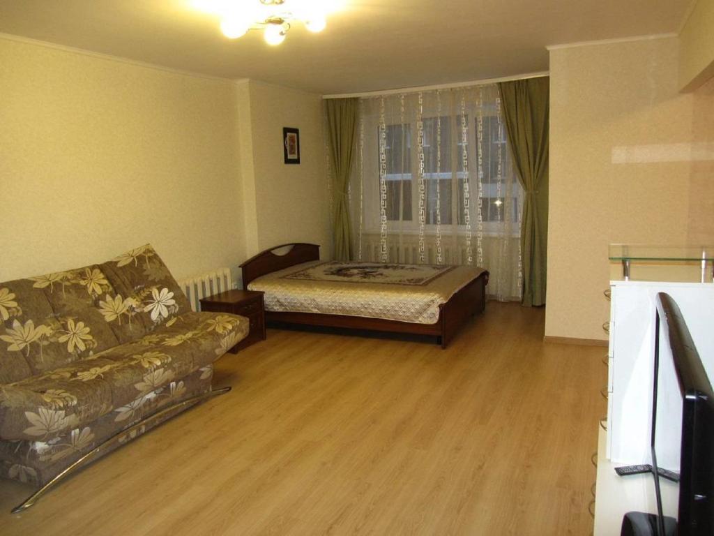 乌法Apartment Revolutsionnaya 72的客厅配有床和沙发