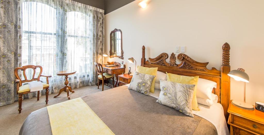 旺格努伊拉特兰阿尔姆旅馆的一间卧室配有一张大床和一张桌子及椅子
