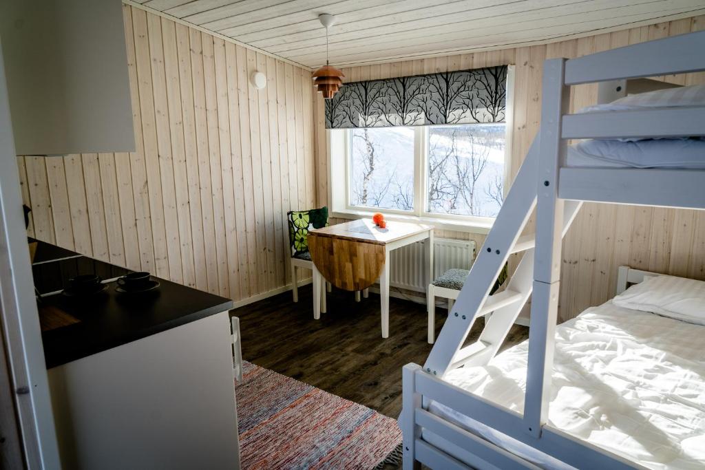 Nikkaluokta伊诺克斯拉迪加夫瑞山林小屋的小房间设有双层床和桌子
