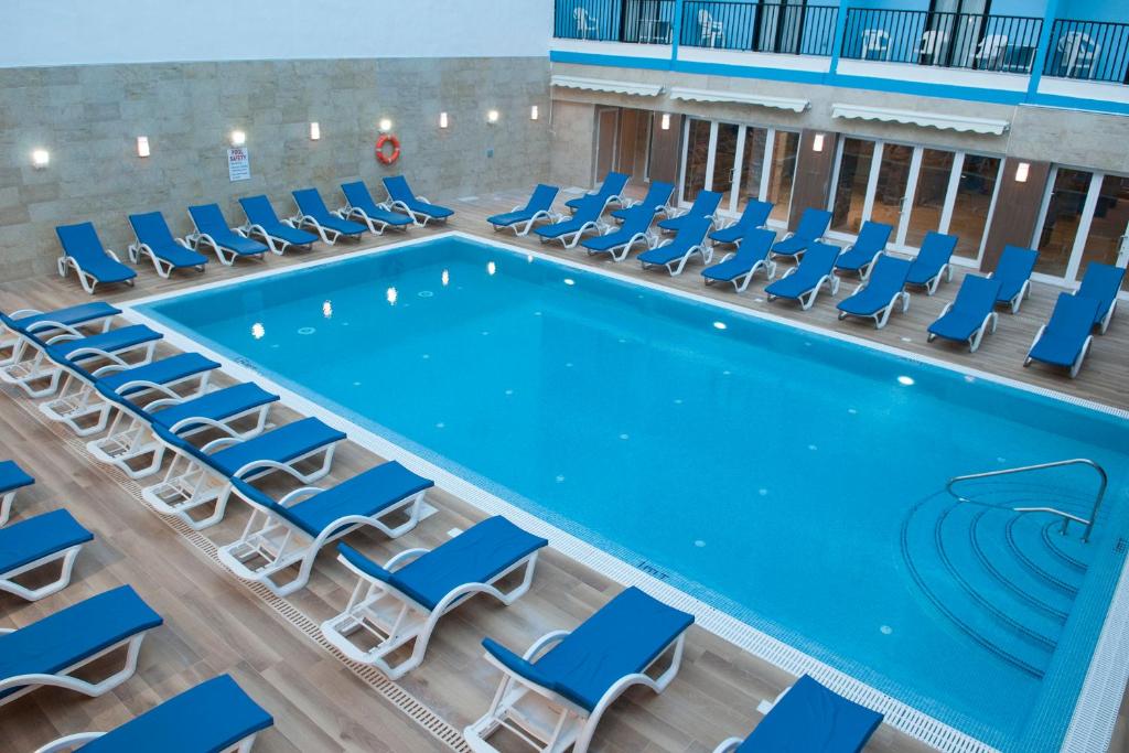 圣保罗湾城欧罗俱乐部酒店的室内游泳池配有椅子和台球桌