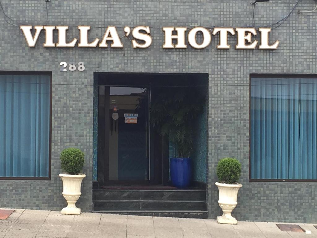 圣保罗Villas Hotel的建筑前有两瓶花的酒店