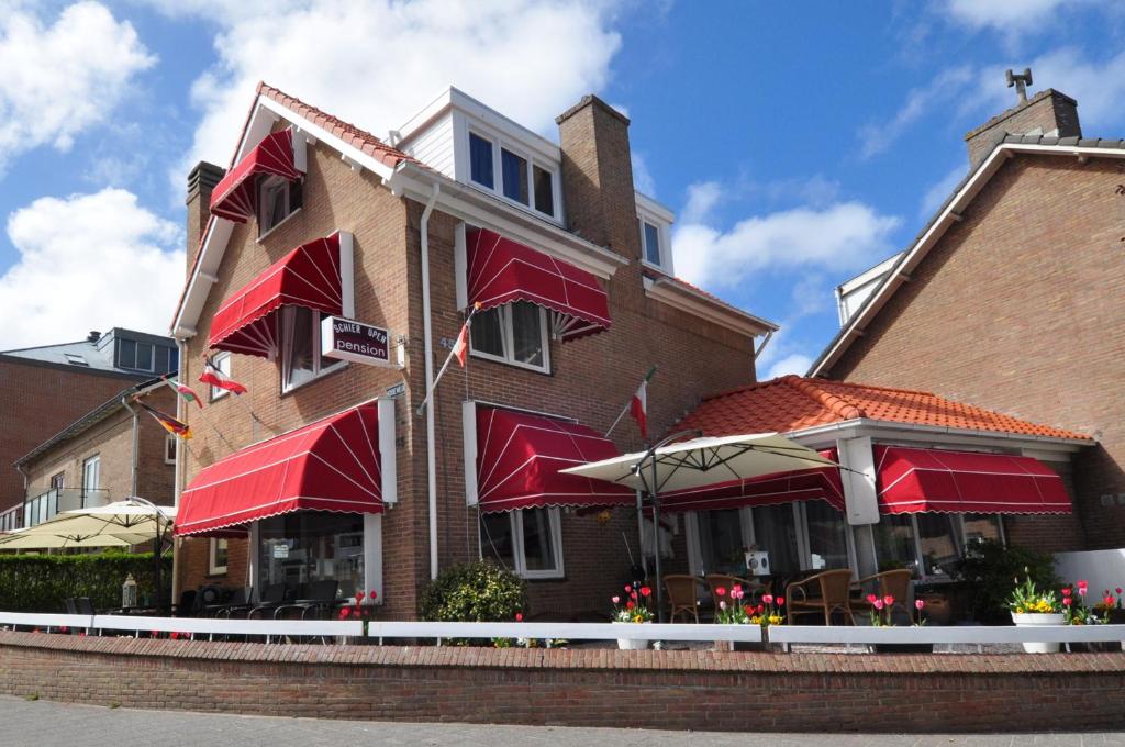 赞德沃特希尔膳食旅店的一座有红色遮阳篷的建筑和一间餐厅