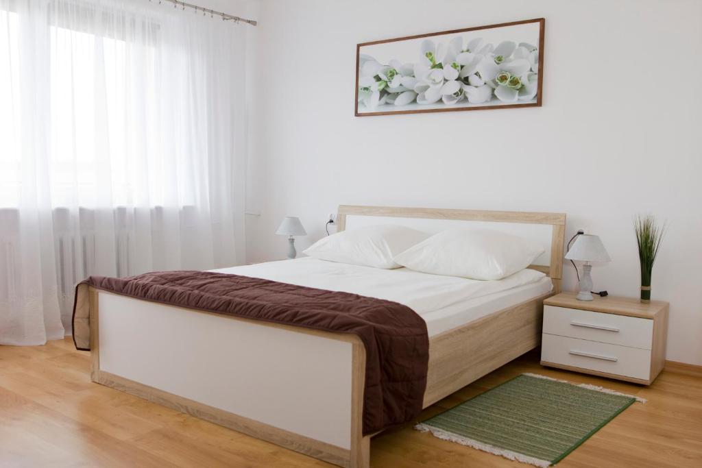 姆瓦瓦Hotel Mława的白色的卧室设有一张大床和一个窗户