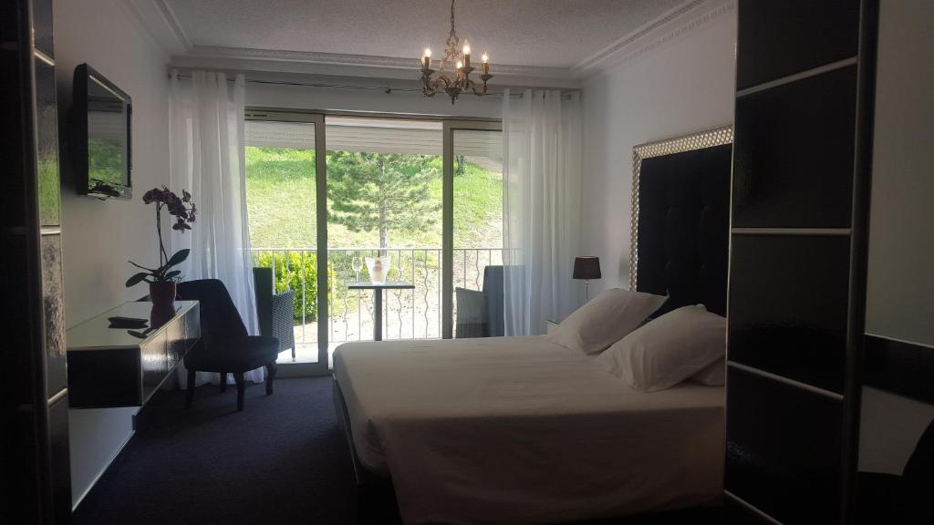 里耶两只狮子酒店的一间卧室配有一张床、一张书桌和一个窗户。