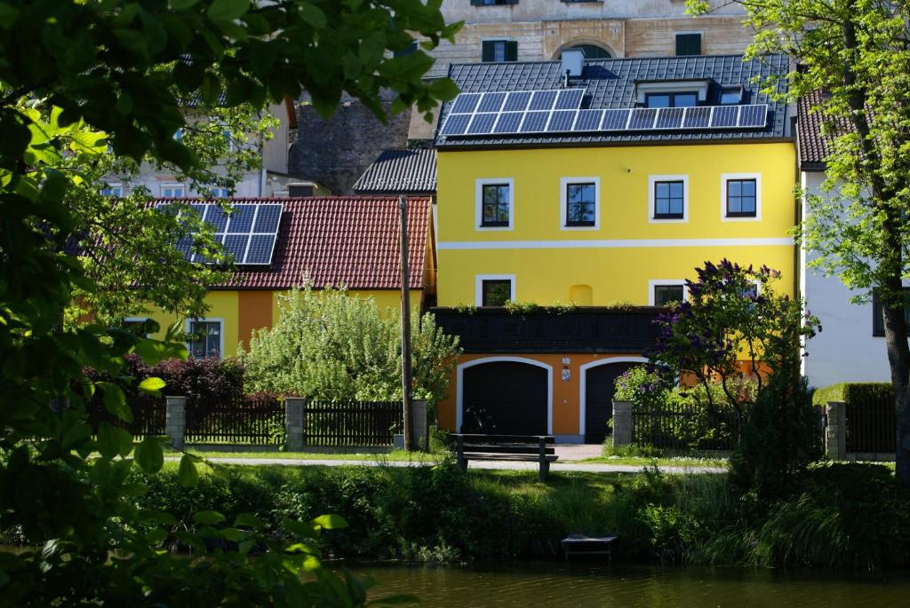 塔亚河畔魏德霍芬陶富纳顶级公寓的屋顶上设有太阳能电池板的黄色房子