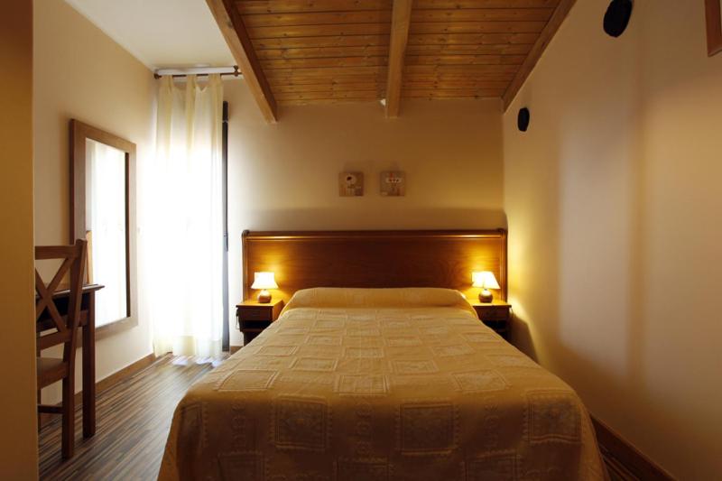 埃尔瓦Apartamentos Hervasypunto的一间卧室配有一张床,窗户配有两盏灯。