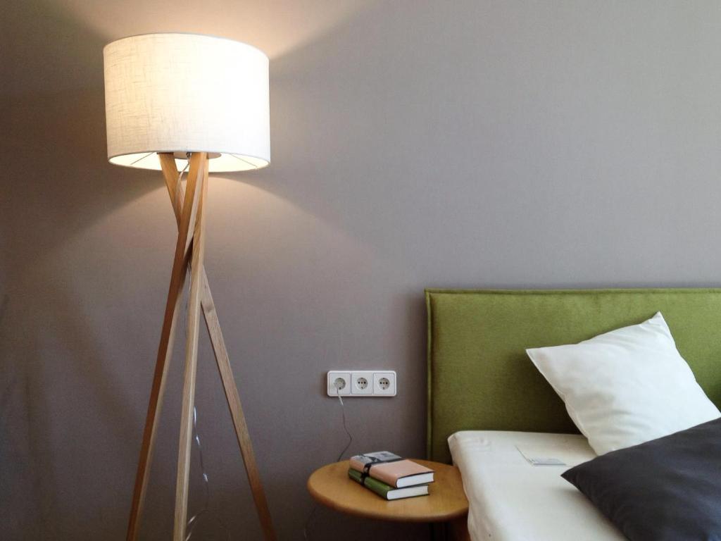 沃尔特湖畔韦尔登Appartements Gästehaus Gallob的一间卧室配有一张带台灯和桌子的床
