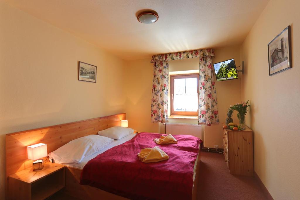博兹达尔绿屋酒店的一间卧室配有一张带红色棉被的床和窗户。