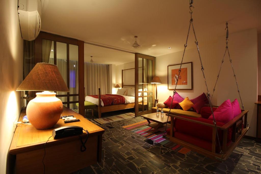 拉杰果德The Sky Imperial Aarivaa Luxury HomeStay的一间带秋千床的客厅和一间卧室