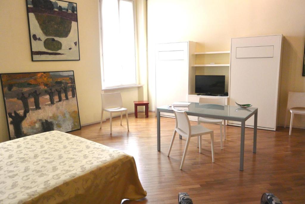曼托瓦阿勒柯尔苏住宅的配有桌椅和电视的客房