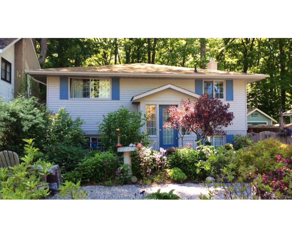 滨湖尼亚加拉Westwood Cottage License #045-2020的蓝色的房子,前面有一个花园