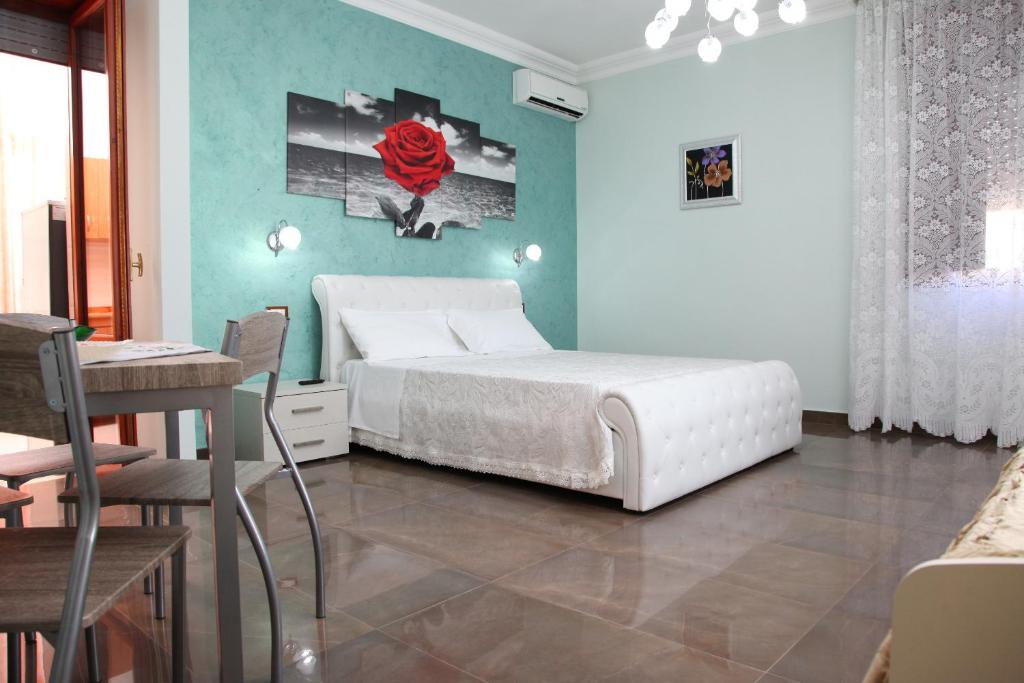 切萨雷奥港Palazzo Primavera的卧室配有白色的床和桌椅
