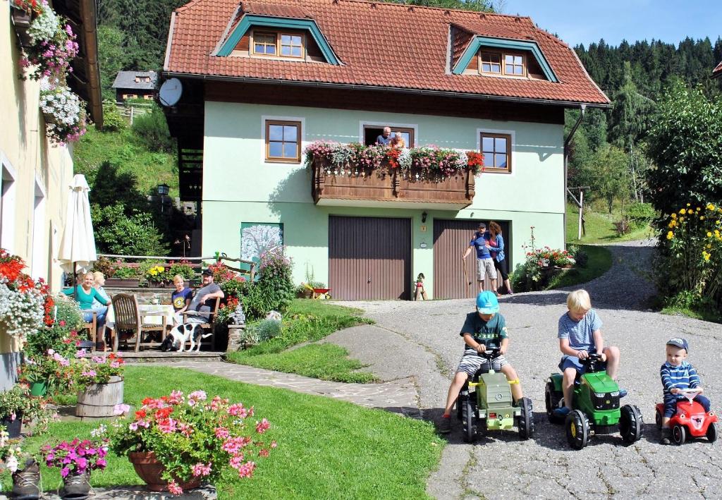 LiebenfelsSchlintl-Hof的一群儿童在房子前骑玩具摩托车