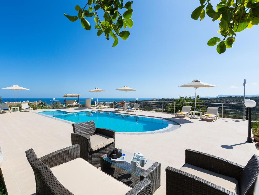 阿德里安诺斯坎波斯Diamantis Villa, a SeaView Retreat, By ThinkVilla的庭院设有游泳池、椅子和桌子。