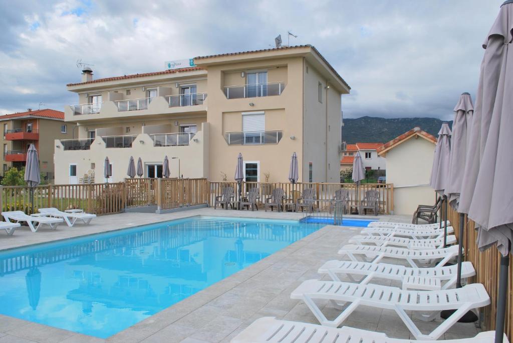 滨海阿热莱斯Hotel Bleu Azur的一座带椅子的游泳池和一座建筑的酒店