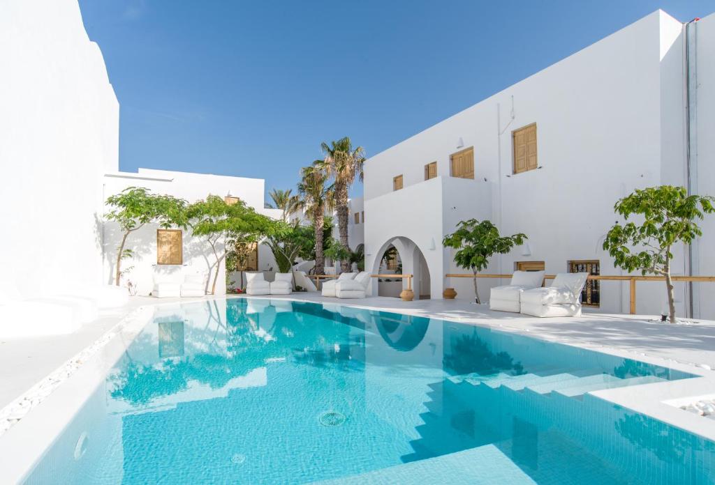 卡马利Santorini Crystal Blue Boutique Hotel的白色建筑前的游泳池