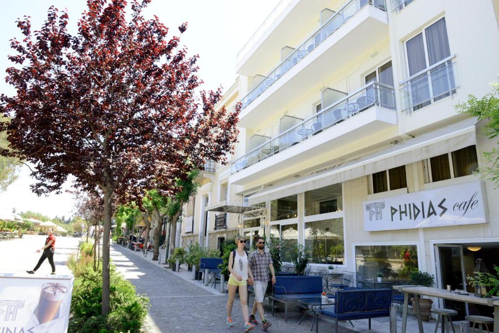 雅典菲迪亚斯酒店的两个人在大楼前的街道上走