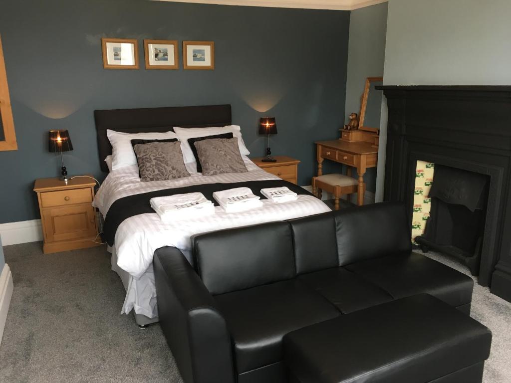布里德灵顿Spaview的一间卧室配有一张床和一张黑色皮沙发