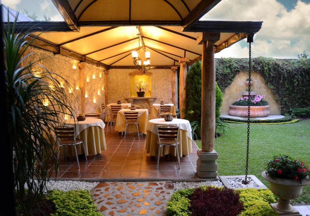 危地马拉Hostal Villa Toscana的一个带桌椅的大伞下的露台