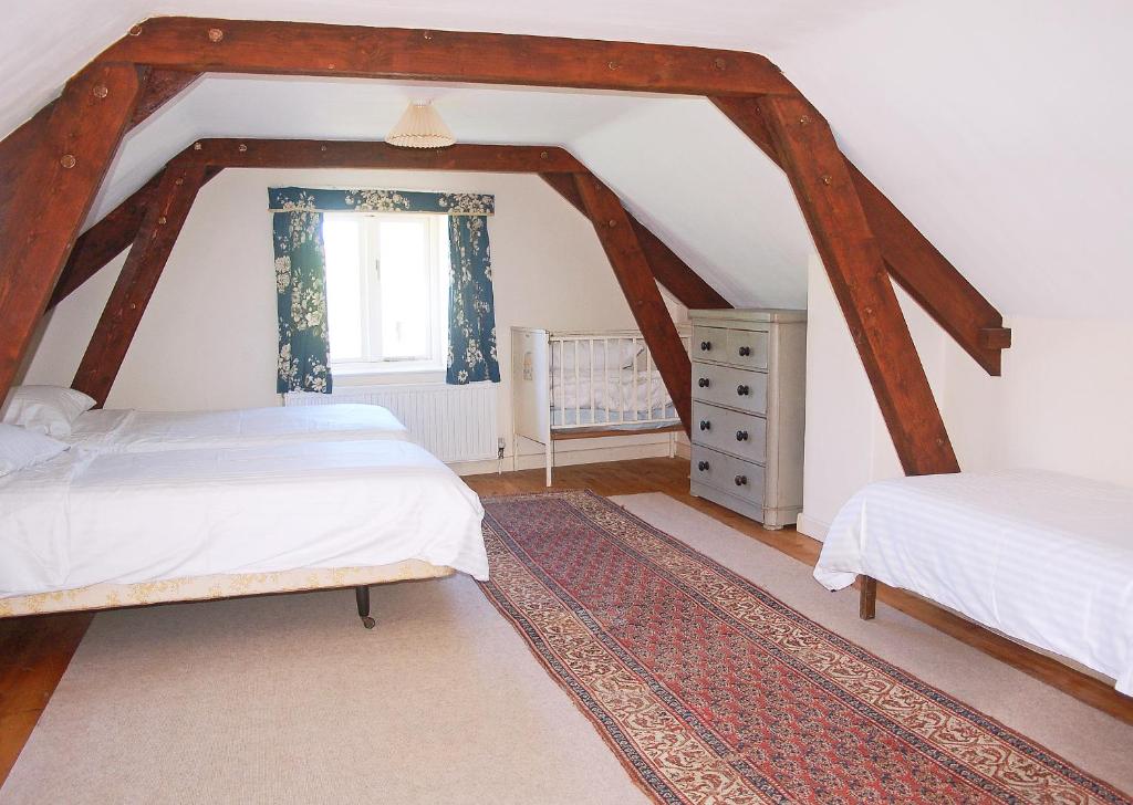 ColytonOld Orchard Cottage的阁楼卧室设有两张床和窗户。