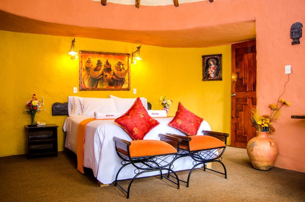 卡瓦纳科德昆图尔瓦西酒店的一间卧室配有一张大床和两把椅子