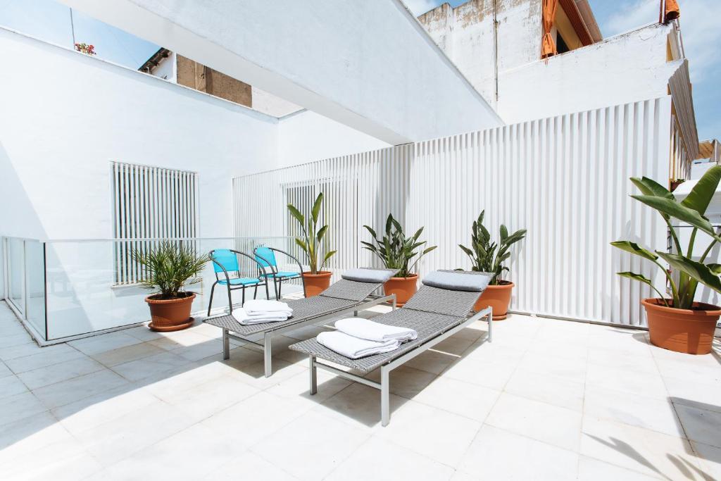 塞维利亚维吉内斯公寓的一座带椅子和植物的庭院