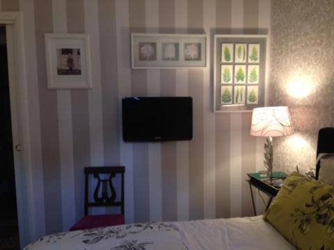 奥斯塔La Finestra Sul Cortile的卧室配有一张床,墙上有一台电视机