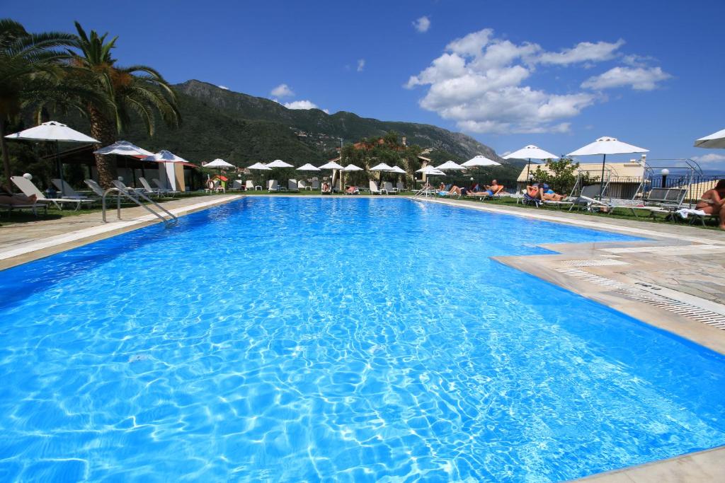 阿普索斯雅尼斯孚酒店的一个带遮阳伞的大型蓝色游泳池