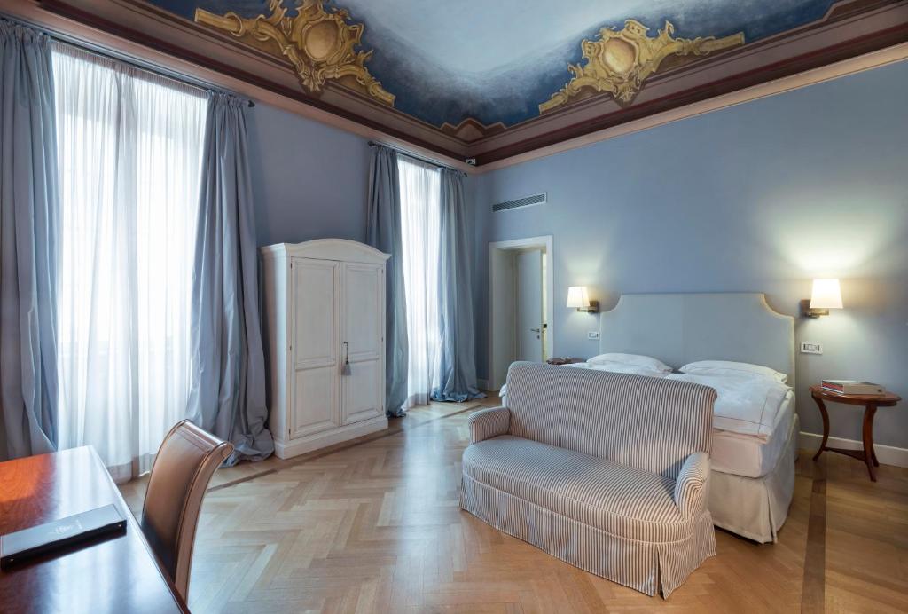 松德里奥德拉波斯塔大酒店的一间卧室配有一张床、一张沙发和一张桌子
