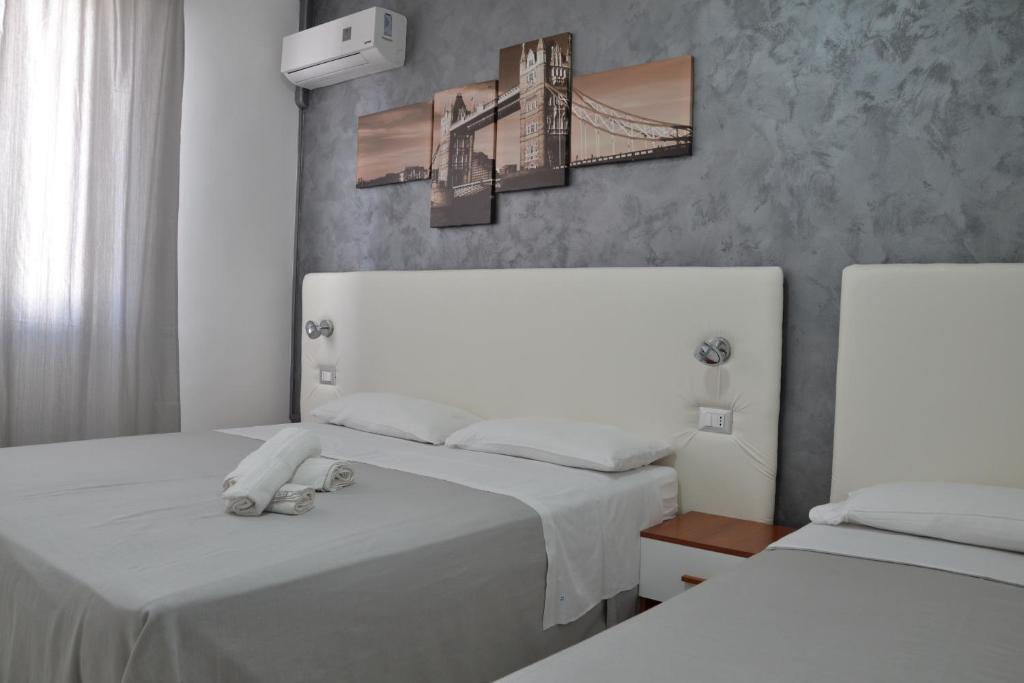托雷拉皮罗B&B Il Molo的一间卧室设有两张床,墙上挂着一幅桥画