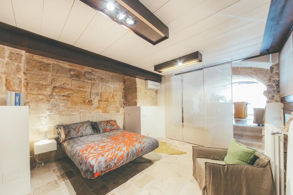 滨海波利尼亚诺La pergola的一间卧室设有一张床和石墙