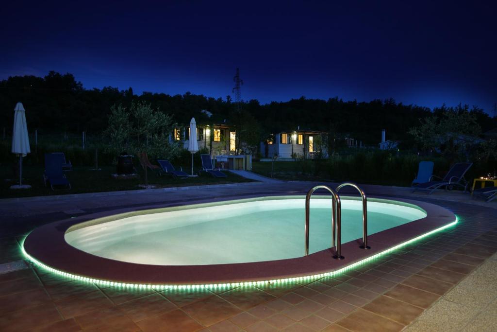 拉宾Mobile Homes Romantik的游泳池,晚上有灯光环绕着它
