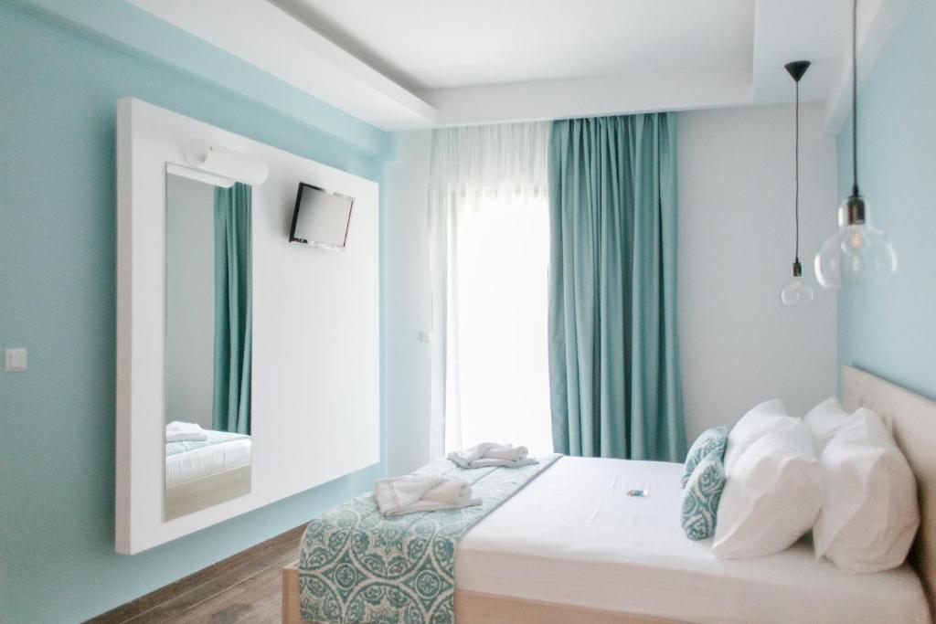 斯卡拉伯塔麦斯Anastasia Rooms的一间卧室配有一张带镜子的床和窗户