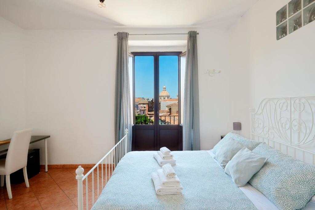 卡塔尼亚Palazzo Currò的一间卧室，配有一张床、一张书桌和一扇窗户