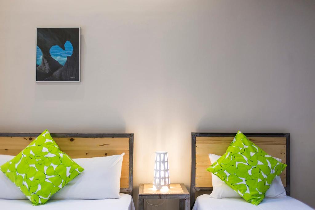 尼亚普拉加Zonita Guest House的两张带绿色和白色枕头的床