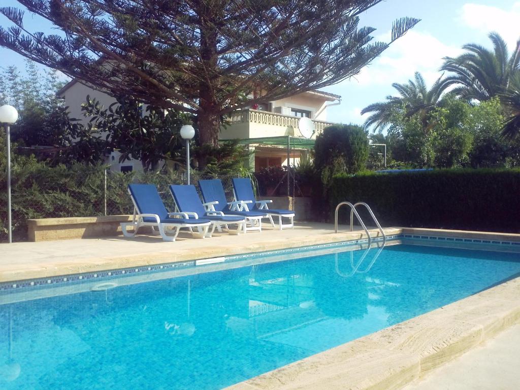 西洛特Finca Sa Gruta Marines的一座房子旁的游泳池,配有蓝色躺椅