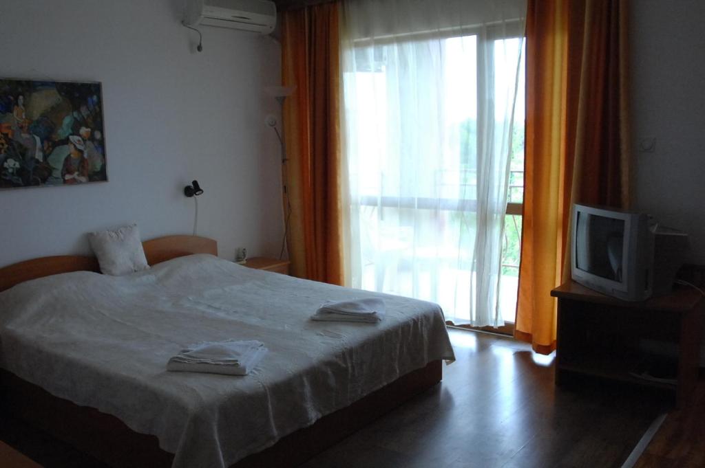 奥布佐尔Condo Hotel Valentina的一间卧室设有一张床、一台电视和一个窗口。