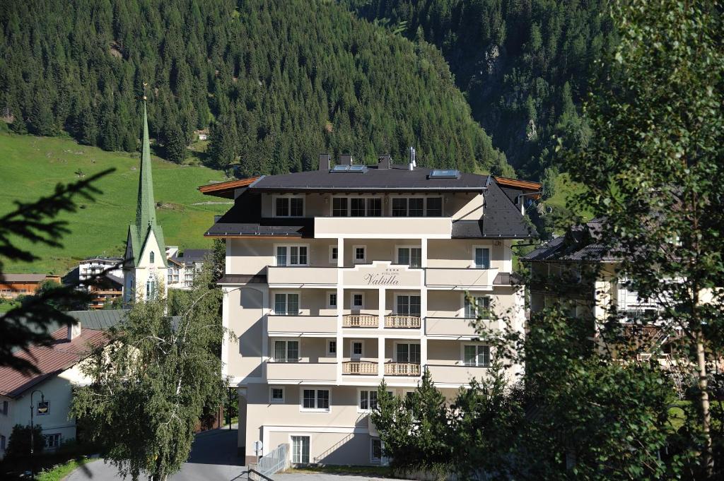 伊施格尔Hotel Garni Valülla的教堂前方的白色大建筑